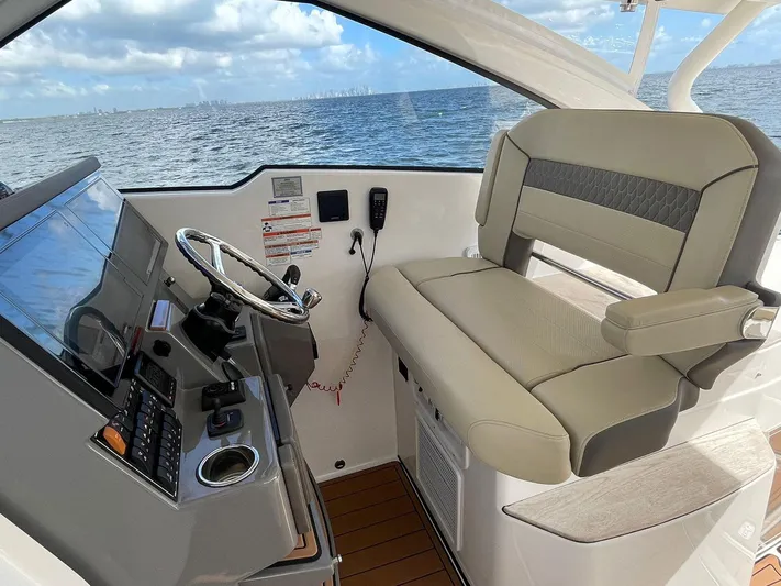Lady B Yacht Photos Pics 2019 Pursuit 365 Dual Console boat interior with helm and seating, overlooking ocean.