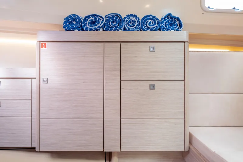 Tramonto Yacht Photos Pics Modern interior of 2021 Fjord 40 Open yacht with wooden cabinetry and rolled blue towels.