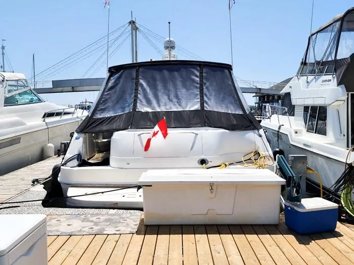  Yacht Photos Pics 1999 Sea Ray 460 Sundancer docked with Canadian flag, surrounded by other boats.