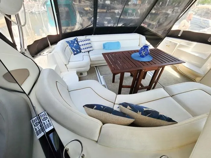  Yacht Photos Pics Luxurious 1999 Sea Ray 460 Sundancer yacht interior with white seating and wooden table.