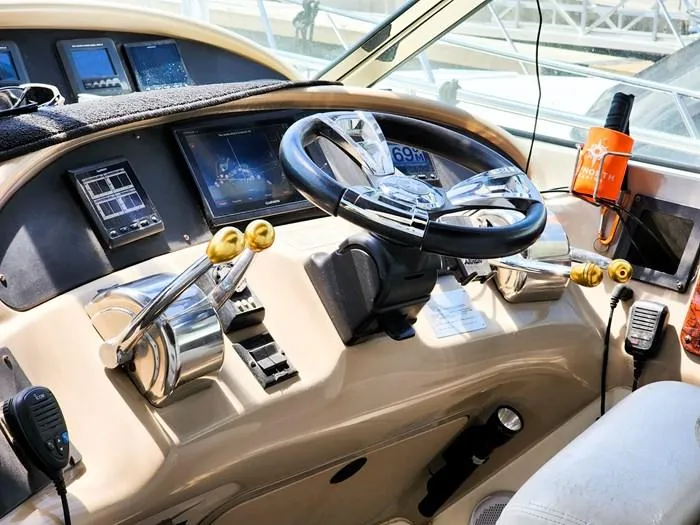  Yacht Photos Pics Control panel of a 1999 Sea Ray 460 Sundancer yacht with steering wheel and navigation instruments.