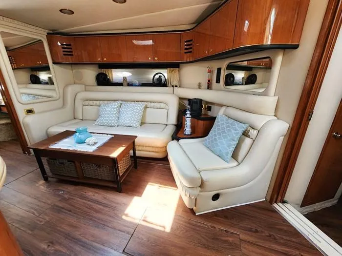  Yacht Photos Pics Luxurious interior of 1999 Sea Ray 460 Sundancer yacht with elegant seating and wooden accents.