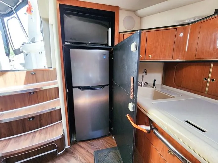  Yacht Photos Pics Interior of 1999 Sea Ray 460 Sundancer yacht with kitchen, fridge, and wooden cabinetry.