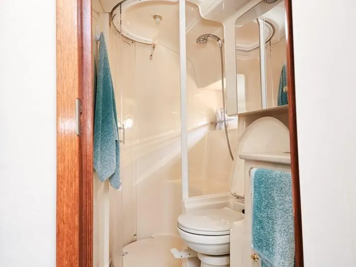  Yacht Photos Pics Bathroom interior of 1999 Sea Ray 460 Sundancer yacht with shower and blue towels.