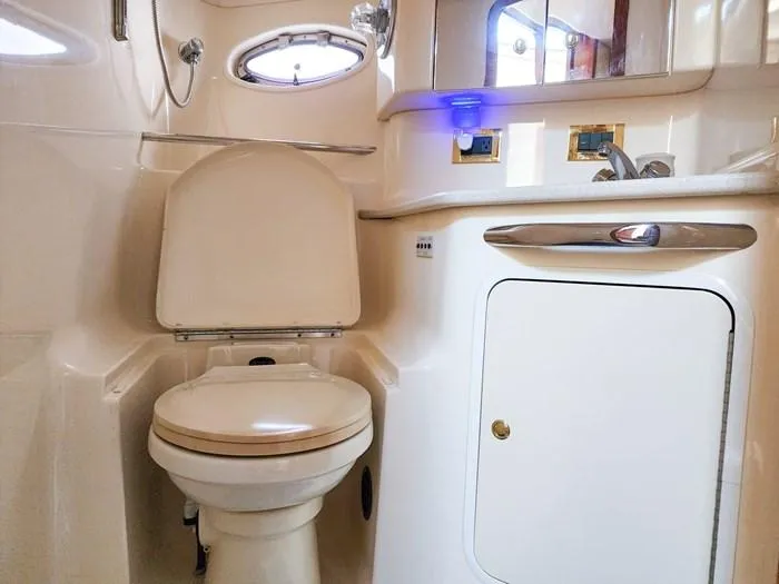  Yacht Photos Pics 1999 Sea Ray 460 Sundancer bathroom with toilet, sink, and storage cabinet.