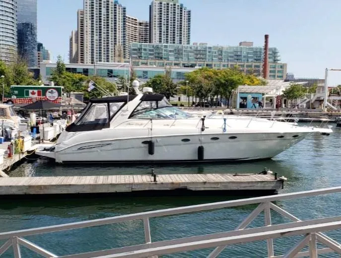  Yacht Photos Pics 1999 Sea Ray 460 Sundancer yacht docked in urban marina with cityscape background.