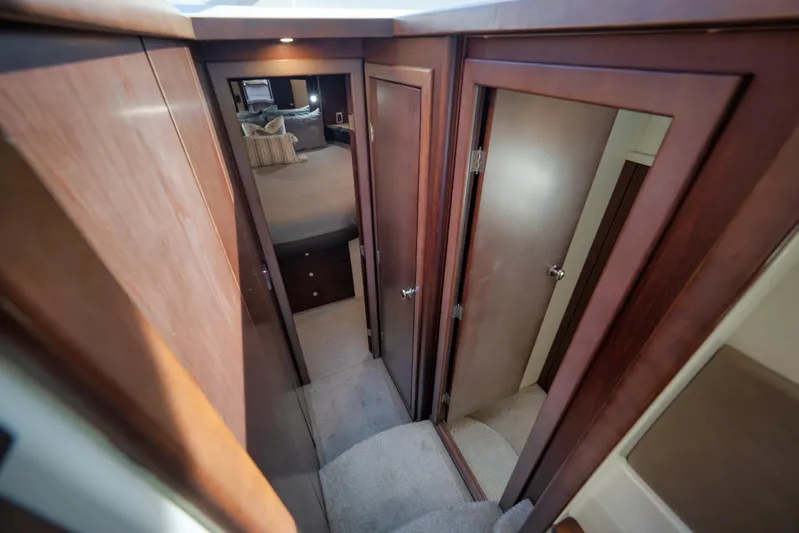  Yacht Photos Pics Interior hallway of 2012 Meridian 441 Sedan yacht with wooden doors and carpeted floor.