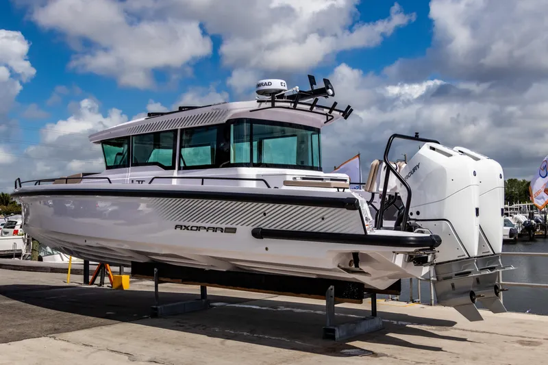 Yacht Photos Pics 2025 Axopar 37XC CROSS CABIN BRABUS Trim boat on display under cloudy sky.