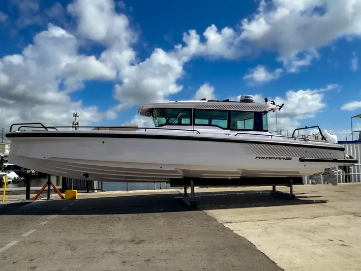  Yacht Photos Pics 2025 Axopar 37XC CROSS CABIN BRABUS Trim boat on display under a blue sky.