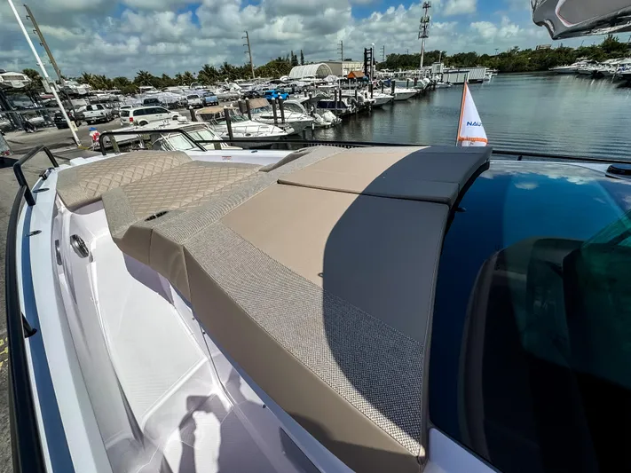  Yacht Photos Pics 2025 Axopar 37XC CROSS CABIN BRABUS Trim boat with sunbathing area, docked at marina.