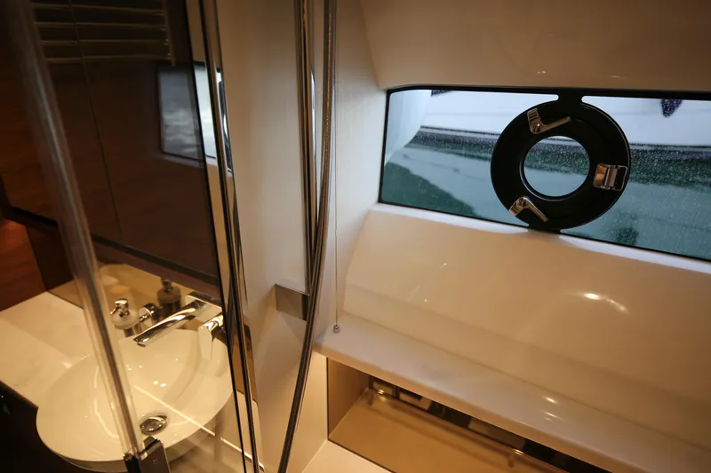  Yacht Photos Pics Luxurious bathroom interior of 2025 Princess F55 yacht with modern fixtures and porthole window.