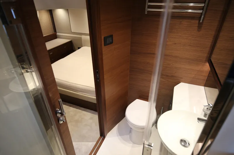  Yacht Photos Pics Luxurious interior of 2025 Princess F55 yacht featuring a cozy bedroom and modern bathroom.