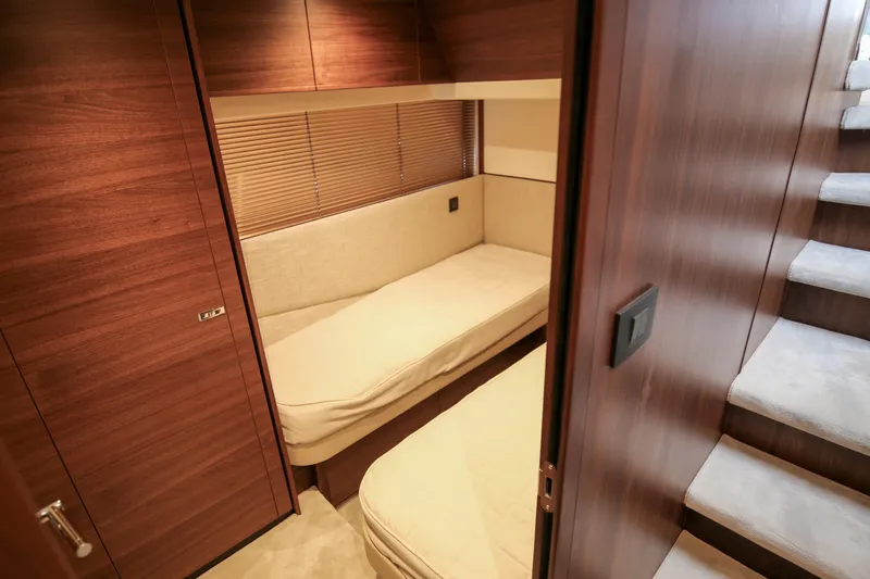  Yacht Photos Pics Luxurious cabin interior of 2025 Princess F55 yacht with twin beds and wooden finish.
