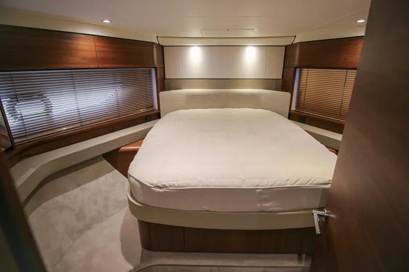  Yacht Photos Pics Luxurious bedroom interior of 2025 Princess F55 yacht with elegant wood finishes.