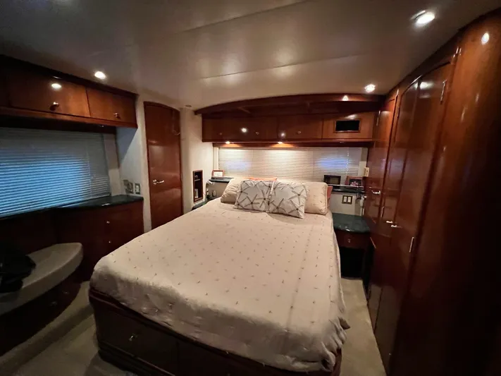  Yacht Photos Pics Luxurious bedroom interior of 2000 Carver 506 Motor Yacht with wood cabinetry and cozy lighting.