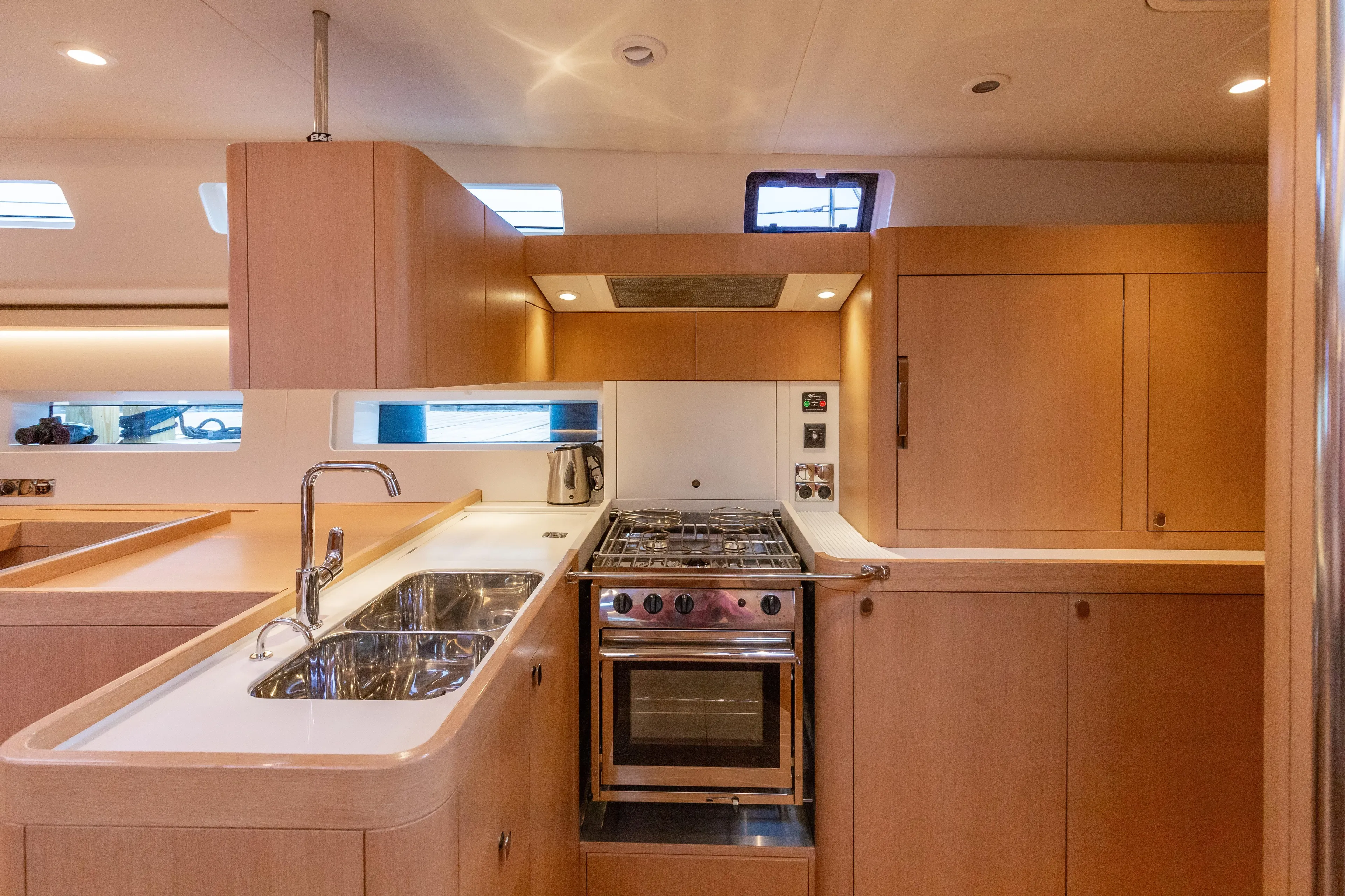 Nehalennia Yacht Photos Pics Modern kitchen interior of 2018 Nautor Swan 54 yacht with wooden cabinetry and stainless steel appliances.