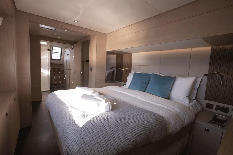  Yacht Photos Pics Luxurious bedroom interior of 2025 Lagoon 60 yacht with modern design and cozy bedding.