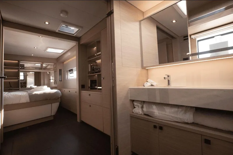  Yacht Photos Pics Luxurious interior of 2025 Lagoon 60 yacht featuring bedroom and modern bathroom.