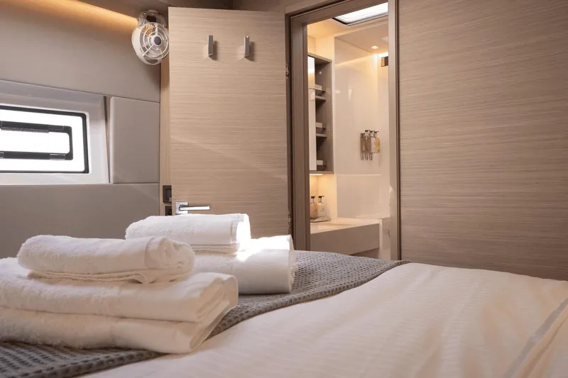  Yacht Photos Pics Luxurious interior of 2025 Lagoon 60 yacht cabin with modern design and plush linens.