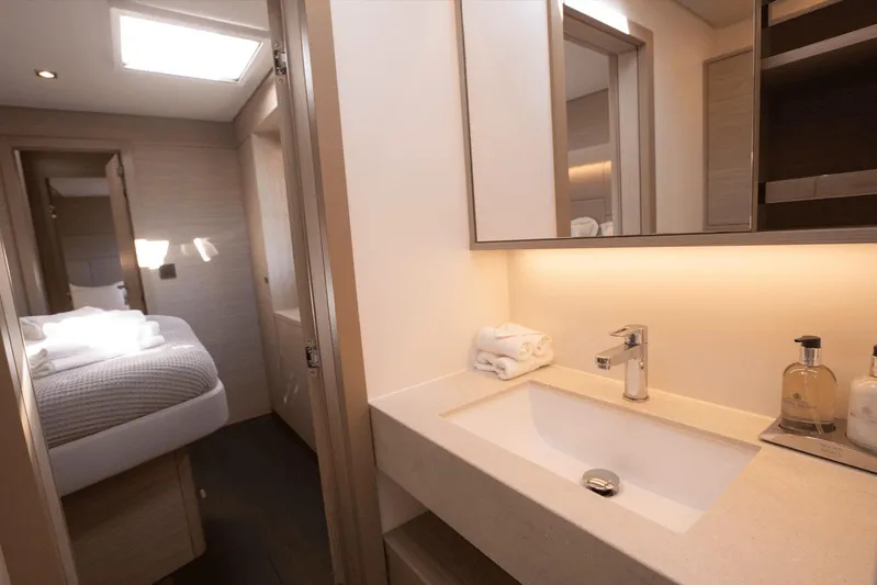  Yacht Photos Pics Luxurious bathroom in 2025 Lagoon 60 yacht with modern fixtures and cozy bedroom view.