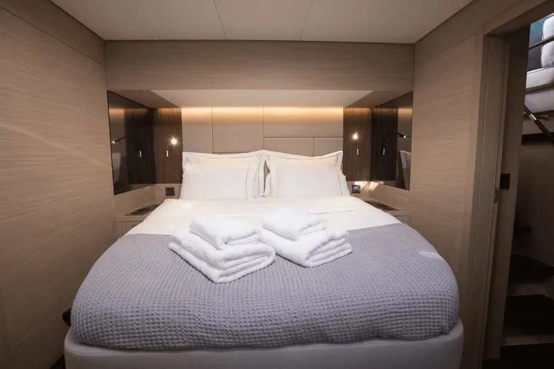  Yacht Photos Pics Luxurious bedroom interior of 2025 Lagoon 60 yacht with elegant bedding and soft lighting.