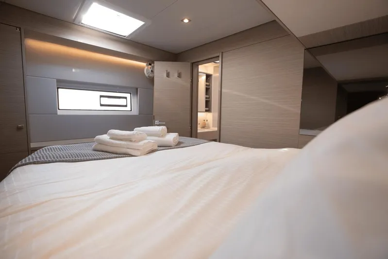  Yacht Photos Pics Luxurious interior cabin of 2025 Lagoon 60 yacht with modern design and cozy bedding.