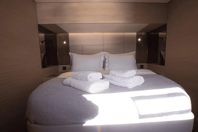  Yacht Photos Pics Luxurious bedroom interior of 2025 Lagoon 60 yacht with neatly arranged towels.