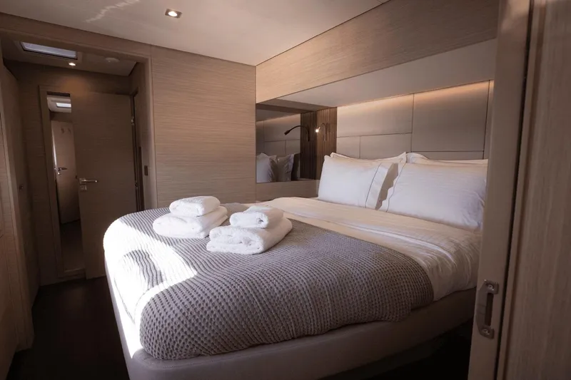  Yacht Photos Pics Luxurious bedroom interior of 2025 Lagoon 60 yacht with cozy bedding and modern design.