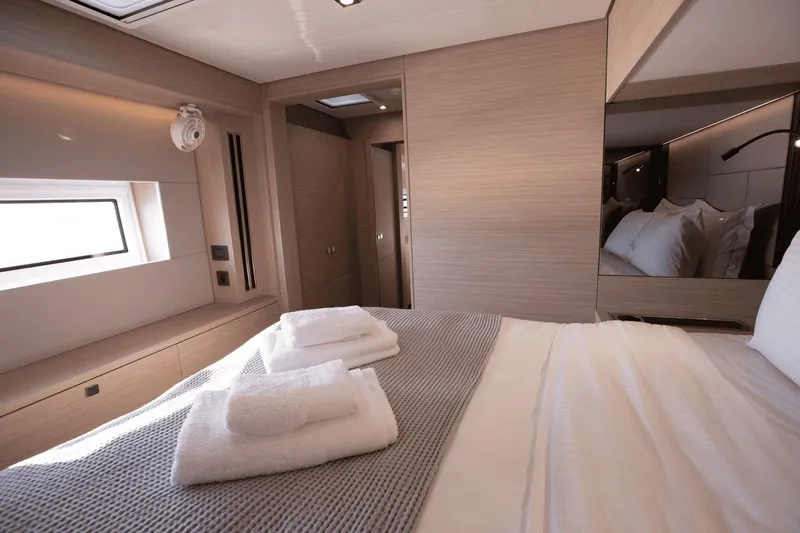  Yacht Photos Pics Luxurious interior cabin of 2025 Lagoon 60 yacht with modern design and cozy bedding.