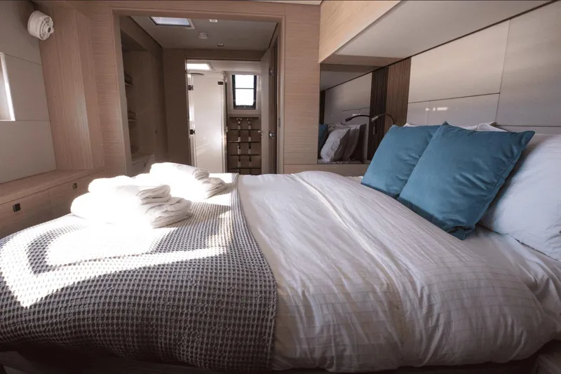  Yacht Photos Pics Luxurious bedroom interior of 2025 Lagoon 60 yacht with cozy bedding and modern design.
