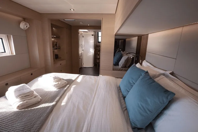 Yacht Photos Pics Luxurious interior of 2025 Lagoon 60 yacht with cozy bedroom and modern design.