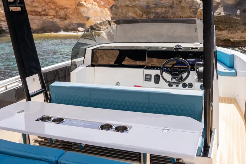  Yacht Photos Pics 2026 De Antonio Yachts D29 interior with modern helm and seating, docked by rocky shore.