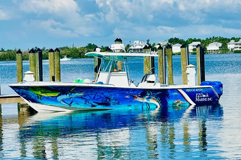  Yacht Photos Pics 2001 Regulator 32 Center Console boat with vibrant marine-themed artwork docked by the water.