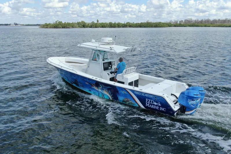  Yacht Photos Pics 2001 Regulator 32 Center Console boat cruising on open water, vibrant marine graphics.