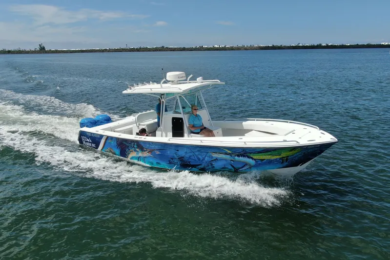  Yacht Photos Pics 2001 Regulator 32 Center Console boat cruising on open water with vibrant marine graphics.