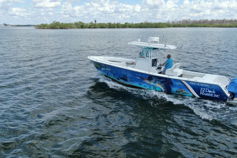 Yacht Photos Pics 2001 Regulator 32 Center Console boat cruising on open water under a cloudy sky.