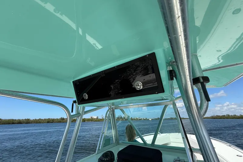  Yacht Photos Pics 2001 Regulator 32 Center Console boat with teal canopy on calm water.