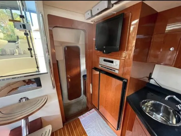  Yacht Photos Pics Interior of 2008 Regal 4060 COMMODORE yacht with wood finish, TV, and kitchenette.