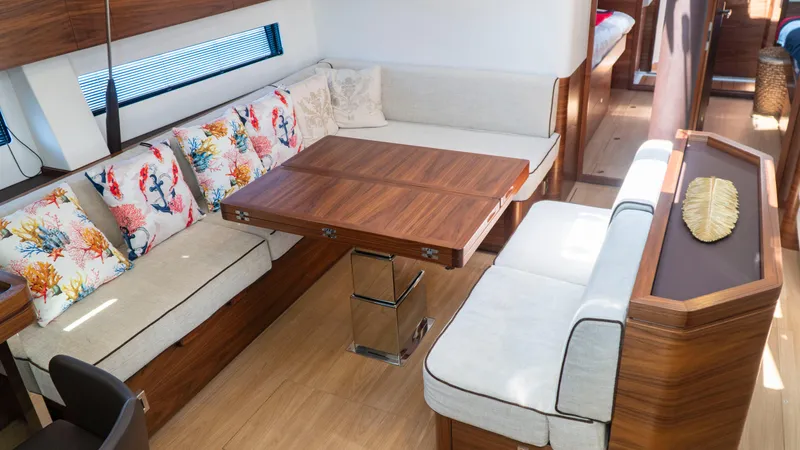  Yacht Photos Pics Interior of a 2021 Amel 60 yacht with wooden table and colorful cushions.