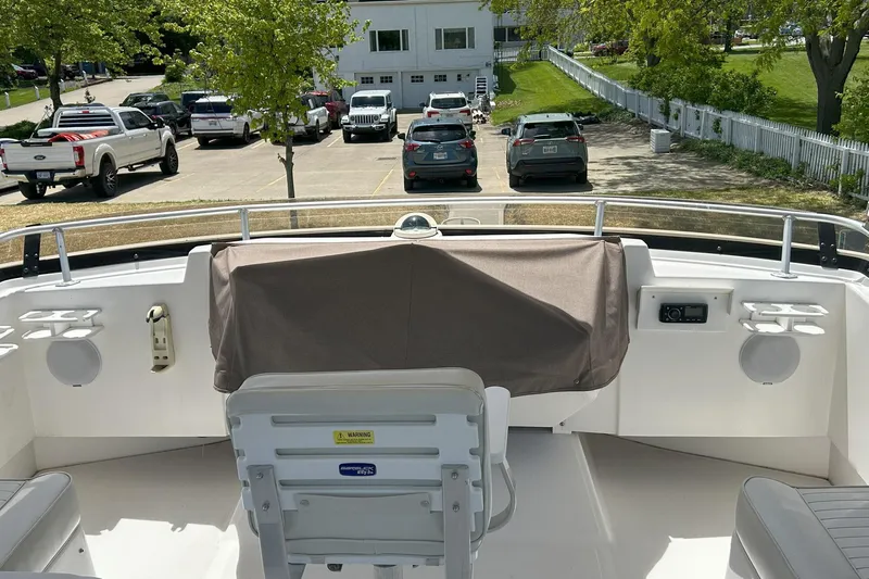 Knot Done Yet Yacht Photos Pics 2002 Mainship 430 Trawler helm with covered controls, overlooking parked cars and greenery.