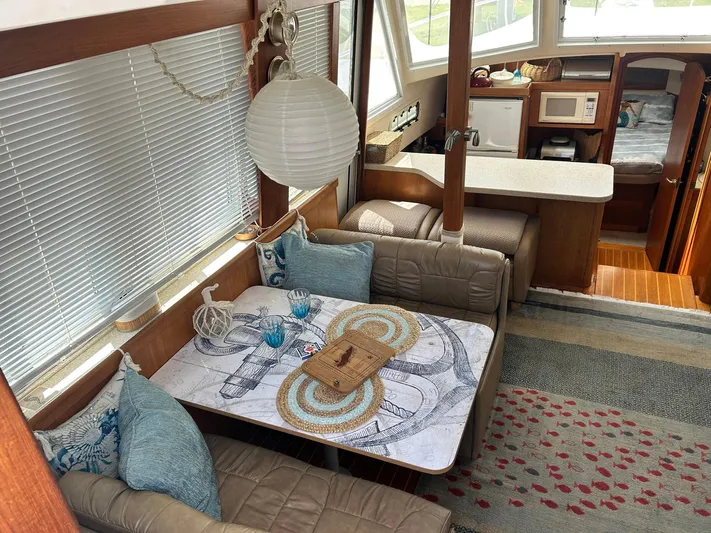 Knot Done Yet Yacht Photos Pics 2002 Mainship 430 Trawler interior with cozy dining area, nautical decor, and modern kitchen amenities.