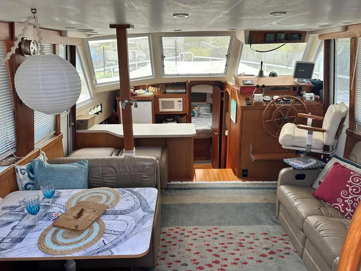 Knot Done Yet Yacht Photos Pics Interior of 2002 Mainship 430 Trawler with cozy seating and nautical decor.