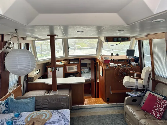 Knot Done Yet Yacht Photos Pics Interior of 2002 Mainship 430 Trawler with helm, seating, and kitchen area.