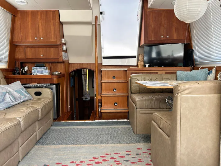 Knot Done Yet Yacht Photos Pics Interior of 2002 Mainship 430 Trawler with leather seating, wooden cabinetry, and a TV.