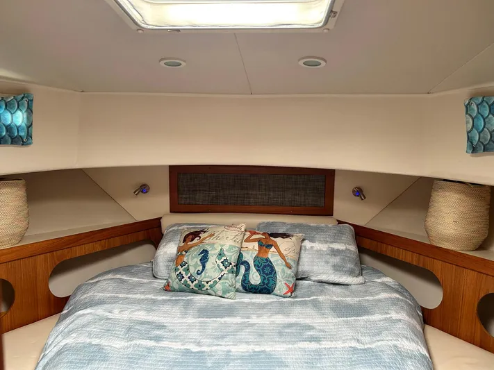 Knot Done Yet Yacht Photos Pics Cozy cabin interior of 2002 Mainship 430 Trawler with nautical-themed bedding and decor.