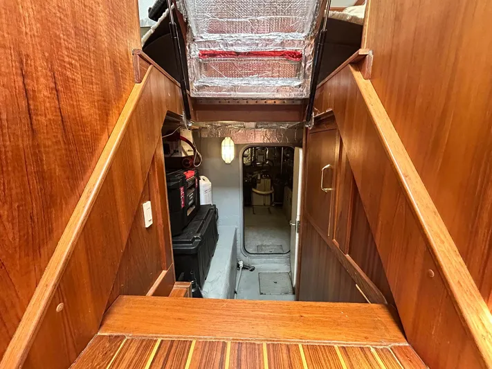 Knot Done Yet Yacht Photos Pics Interior view of 2002 Mainship 430 Trawler, featuring wooden stairs and engine room access.