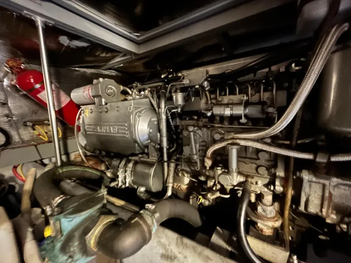 Knot Done Yet Yacht Photos Pics Engine room of a 2002 Mainship 430 Trawler with visible machinery and fire extinguisher.