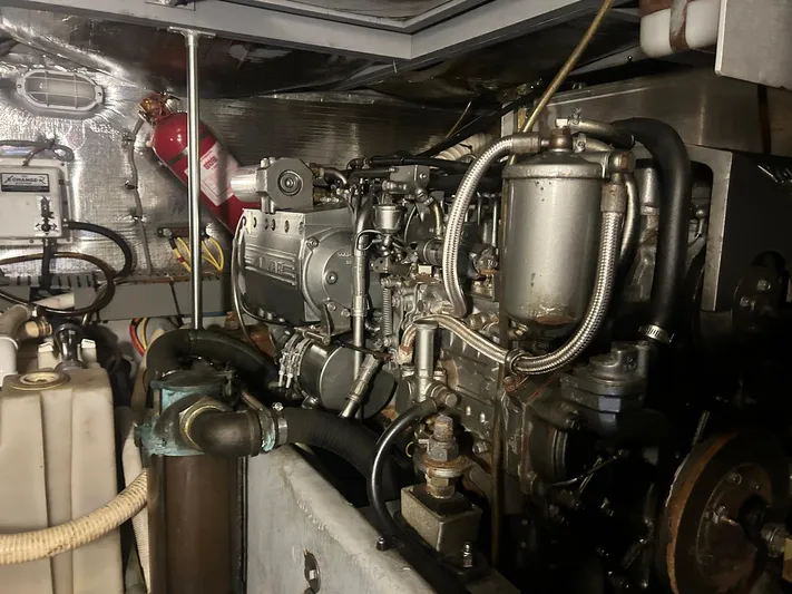 Knot Done Yet Yacht Photos Pics Engine room of a 2002 Mainship 430 Trawler with visible machinery and fire extinguisher.