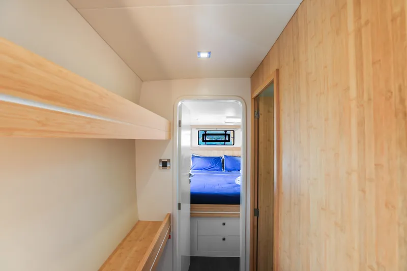 Pom III Yacht Photos Pics Luxurious interior of 2018 Outremer 5X yacht with wooden finishes and cozy bedroom.