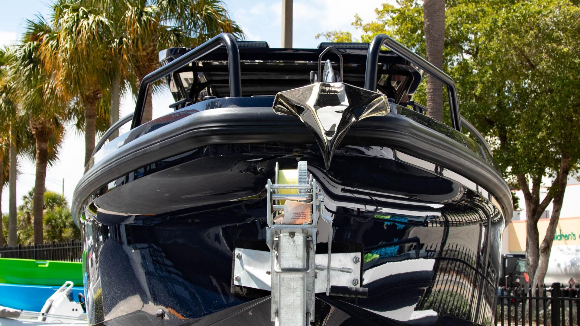 2023 BRABUS Shadow 900 ST boat front view, docked with palm trees in the background.